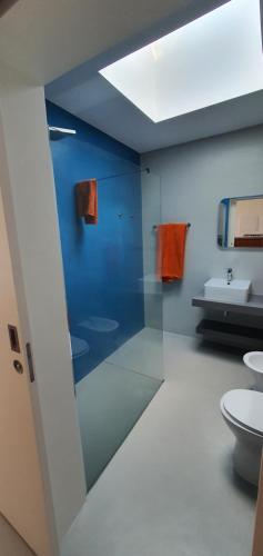 baño con 2 aseos y pared azul en Arrenquinha Guesthouse 2 en Ponta Delgada