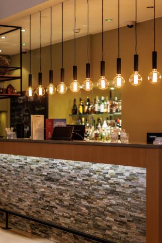 a bar at a restaurant with lights above it at Akureyri - Berjaya Iceland Hotels in Akureyri