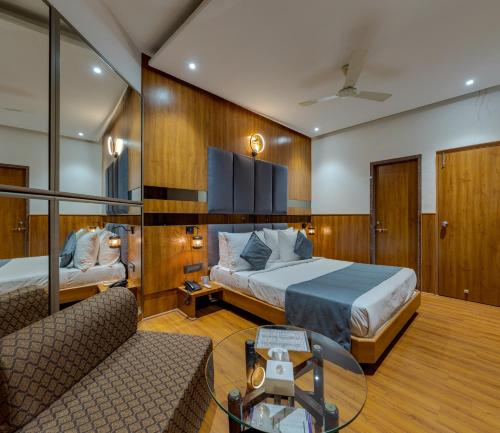 a bedroom with a bed and a couch and a table at Hotel Surya Executive 3 Star Hotel in Solapur