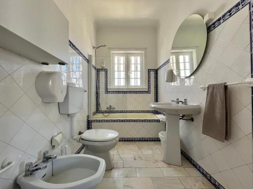 a white bathroom with a sink and a toilet at Eco Ljmonade Hostel in Cascais