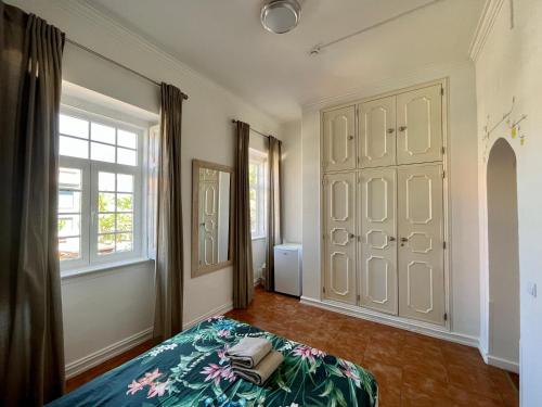 a bedroom with a bed and a large window at Eco Ljmonade Hostel in Cascais