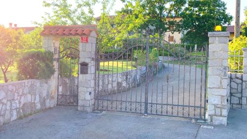a gate to a park with a playground behind it at Garden Villa in Štanjel