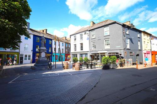 a street in a town with buildings and a statue at Long Quay Apartments, Clonakilty in Clonakilty
