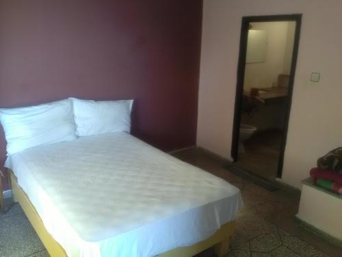 Schlafzimmer mit einem Bett mit weißer Bettwäsche und einem Spiegel in der Unterkunft Beach house in Kenitra