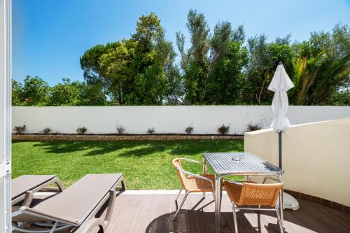 a patio with a table and chairs and a fence at AlvorMar Apartamentos Turisticos in Alvor