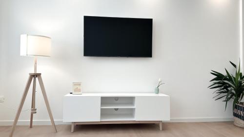 een witte woonkamer met een tv aan een witte muur bij Atelier Rimini - Affitti Brevi Italia in Rimini