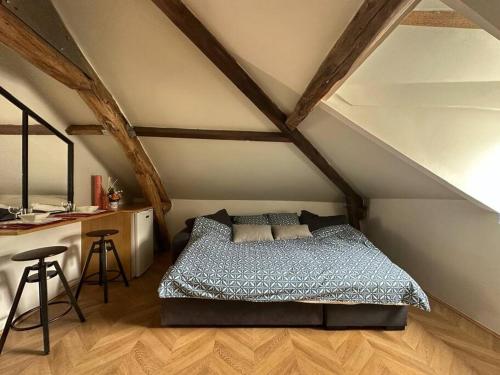 a bedroom with a bed and a desk in a attic at Centre ville d'Enghien in Enghien-les-Bains
