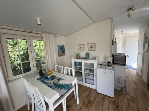 een keuken met een witte tafel en een witte koelkast bij ZP 470 - Camping de Zandput in Vrouwenpolder