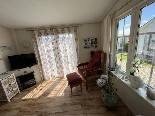 een woonkamer met een stoel en een televisie bij ZP 470 - Camping de Zandput in Vrouwenpolder
