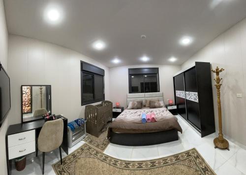 a bedroom with a bed and a desk and a bed sidx sidx sidx at Abu Hossam s chalet in Jerash
