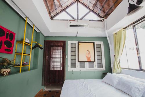 a bedroom with a white bed and a window at CAMP Dakao a curated accomodation in Ho Chi Minh City