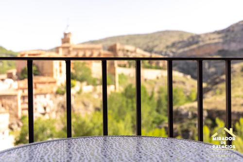 a table on a balcony with a view of a city at Mirador de Palacios- céntrico con vistas y parking cerca in Albarracín