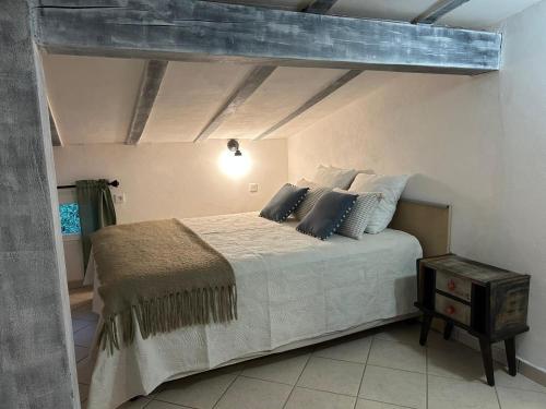 une chambre avec un grand lit avec des oreillers dessus dans l'établissement La VILLA, au Cannet-des-Maures