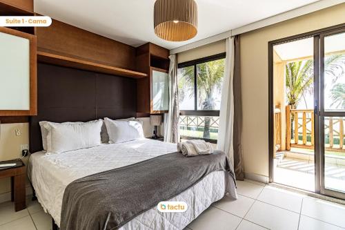- une chambre avec un grand lit et une grande fenêtre dans l'établissement Bangalô vista mar no VG Sun Cumbuco por Tactu, à Cumbuco