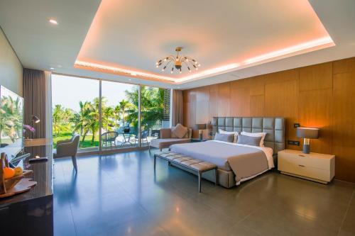 a bedroom with a bed and a couch at Ocean Villa Pool Retreat In Da Nang in Da Nang