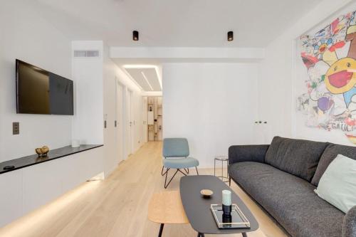 uma sala de estar com um sofá e uma mesa em Magnificent renovated 4-room apartment - Croisette Carre d'or em Cannes