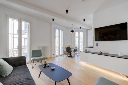 uma sala de estar com um sofá e uma mesa em Magnificent renovated 4-room apartment - Croisette Carre d'or em Cannes