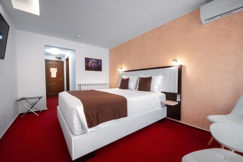 a hotel room with a large bed and a red carpet at Km ZerO - Vama Veche in Vama Veche