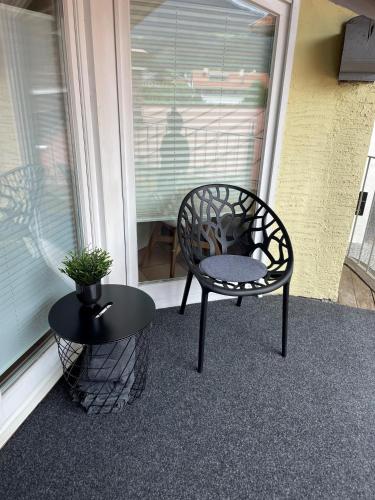 a chair and a table on a porch with a window at Ferienwohnungen Egger in Hopfgarten im Brixental