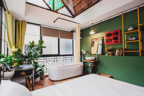 - une chambre avec un lit et un mur vert dans l'établissement CAMP Dakao a curated accomodation, à Hô-Chi-Minh-Ville