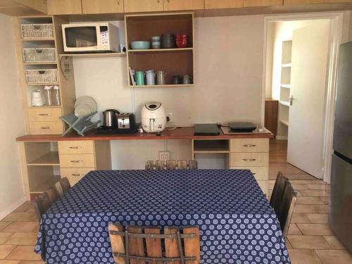 uma cozinha com uma mesa com uma toalha de mesa azul e branca em Self-catering two-bedroom flat Scottsville PMB em Pietermaritzburg