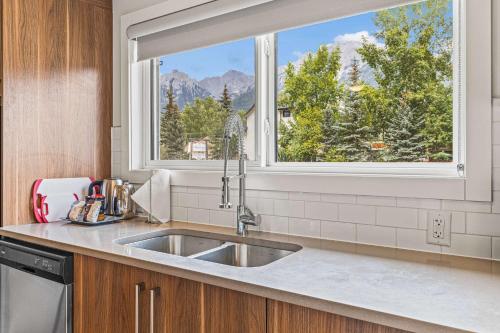 a kitchen with a sink and a window at Basecamp Resorts Canmore in Canmore