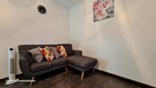 a couch sitting in a corner of a room at Flourish House in Kent