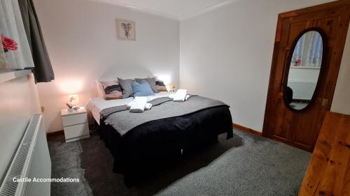 1 dormitorio con cama con almohadas azules y espejo en Flourish House, en Kent