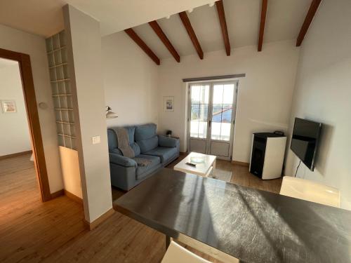 a living room with a blue couch and a tv at Bahía de Pedreña in Pedreña