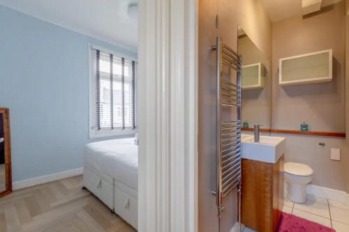 a bathroom with a bed and a sink and a toilet at Tasteful & Homely 1BD Flat - Brixton in London