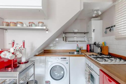 a kitchen with a washing machine and a sink at Tasteful & Homely 1BD Flat - Brixton in London