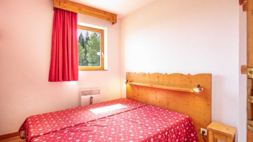 - une chambre avec un lit doté d'un couvre-lit rouge et d'une fenêtre dans l'établissement V du Bachat- MELEZES A31- 4P, à Chamrousse
