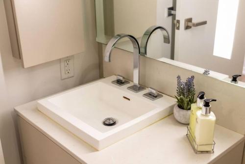 a bathroom with a white sink and a mirror at Exec 1 BR Ent District MTCC Jays with Parking in Toronto