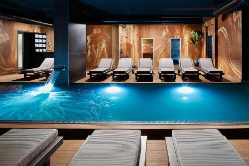 a swimming pool with chairs in a waiting room at 21st Century Zlatibor Residence, Spa & Wellness by Adora in Zlatibor