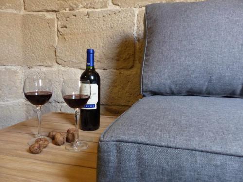Una botella de vino y dos copas en una mesa. en Apartamento Ábside de San Juan I, en Estella