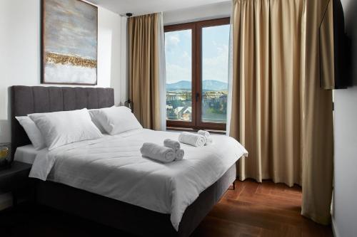 a bedroom with a bed with towels on it at 21st Century Zlatibor Residence, Spa & Wellness by Adora in Zlatibor
