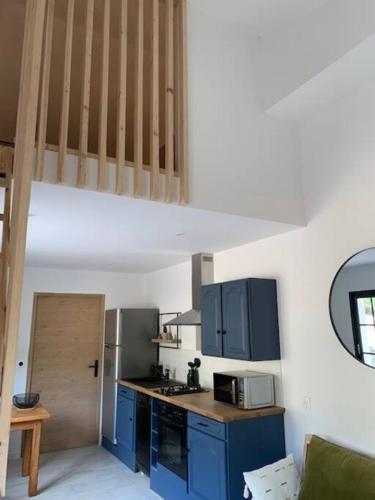 une cuisine avec des armoires bleues et un comptoir dans l'établissement Casa del Sola, à Mosset