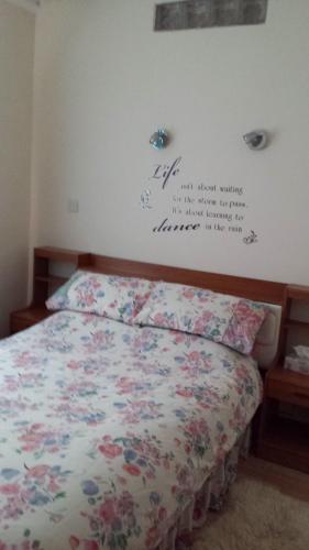 sypialnia z łóżkiem z kwiatami na ścianie w obiekcie Weaver's House B and B w Cardiff