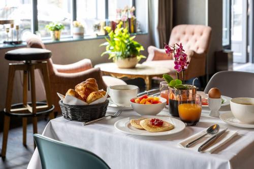 a table with a white table cloth with breakfast foods on it at H&ocirc;tel Fabric in Paris