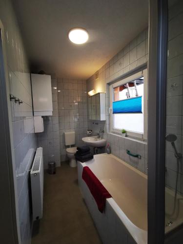 a bathroom with a tub and a sink and a toilet at Ferienwohnung Krayenbergblick 2 in Tiefenort