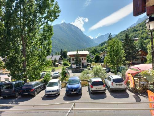 un montón de autos estacionados en un estacionamiento en Chambre Quadruple avec Salle de Bains Privative 1 en Vallouise