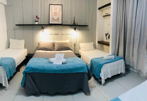 a room with two beds with blue and white sheets at Aconchego Carioca Ipanema Copacabana Rua da praia in Rio de Janeiro