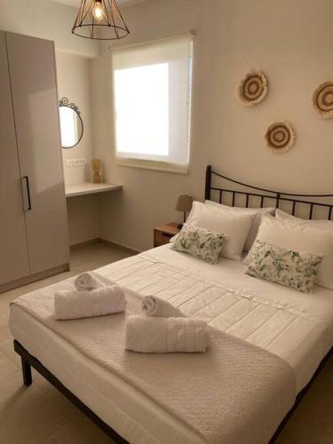 a bedroom with a large white bed with towels on it at Thalassa Grammeno seaview house in Palaiochora