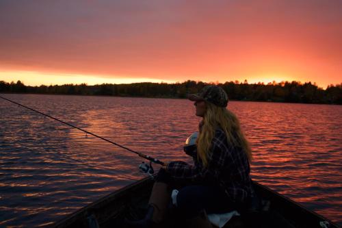 a woman and a child in a boat with a fishing pole at Villa Åmmeberg in Åmmeberg