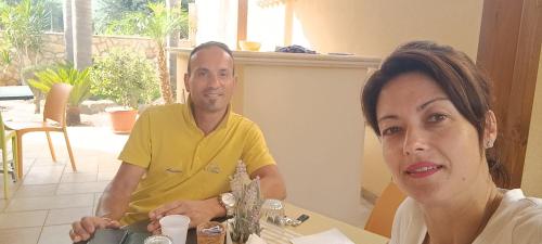 a man and a woman sitting at a table at Le Falesie di Castelluzzo in Castelluzzo