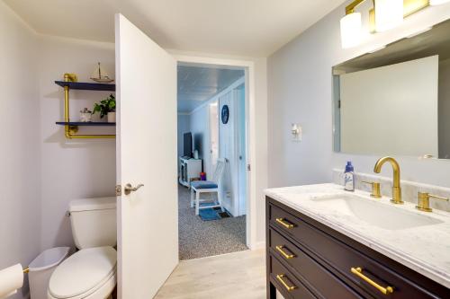 a bathroom with a sink and a toilet and a mirror at Lakefront Vacation Rental, 13 Mi to South Haven! in Grand Junction