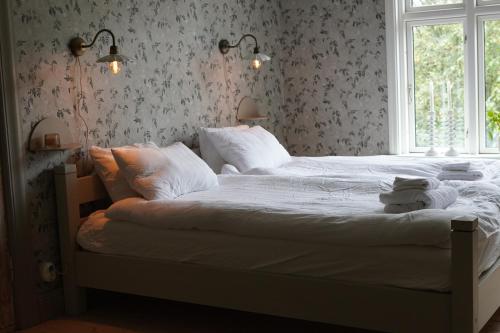 a bedroom with a bed with white sheets and a window at Villa Åmmeberg in Åmmeberg