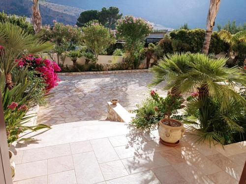 a patio with a bunch of plants and flowers at Le Falesie di Castelluzzo in Castelluzzo