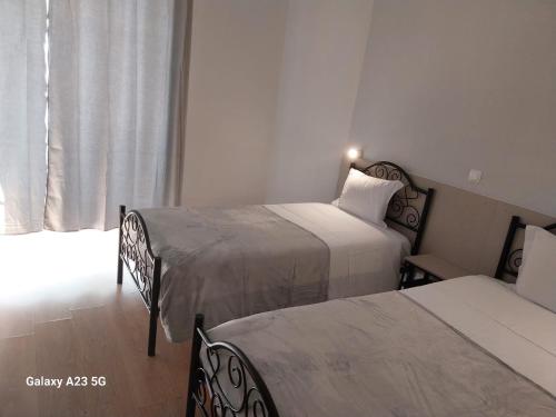 a hotel room with two beds and a window at Pensao Nova Goa in Lisbon