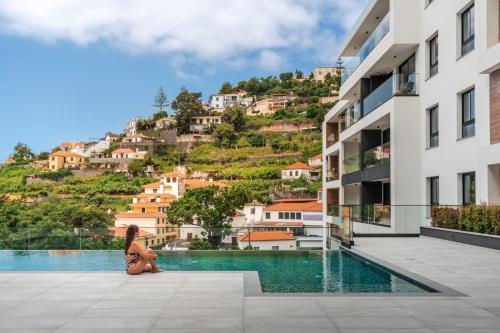 a woman squatting next to a pool in a building at Uptown 13 apartment by An Island Apart in Funchal